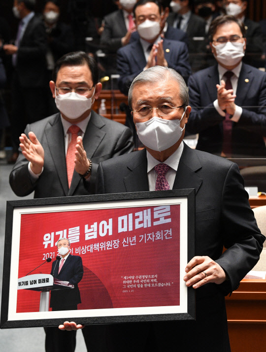 4.7 재보궐선거를 승리로 이끈 직후 국민의힘을 떠나는 김종인 비상대책위원장이 8일 오전 서울 여의도 국회에서 열린 의원총회에 참석, 기념액자를 받고 있다.[사진=연합뉴스]